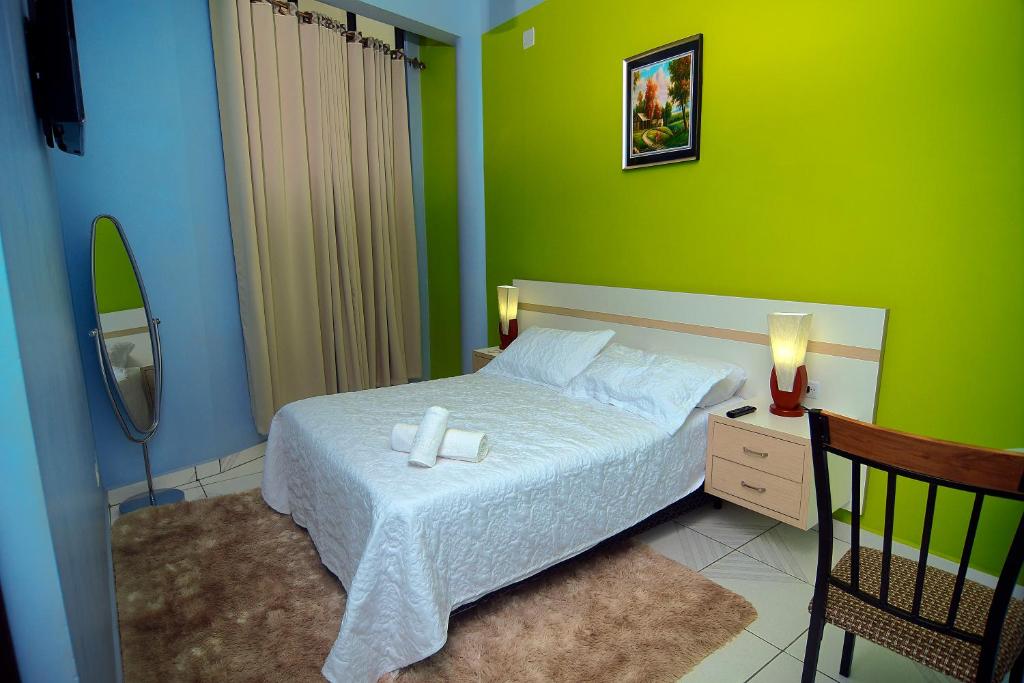 a bedroom with a bed and a green wall at Amazonia Hotel in Cobija
