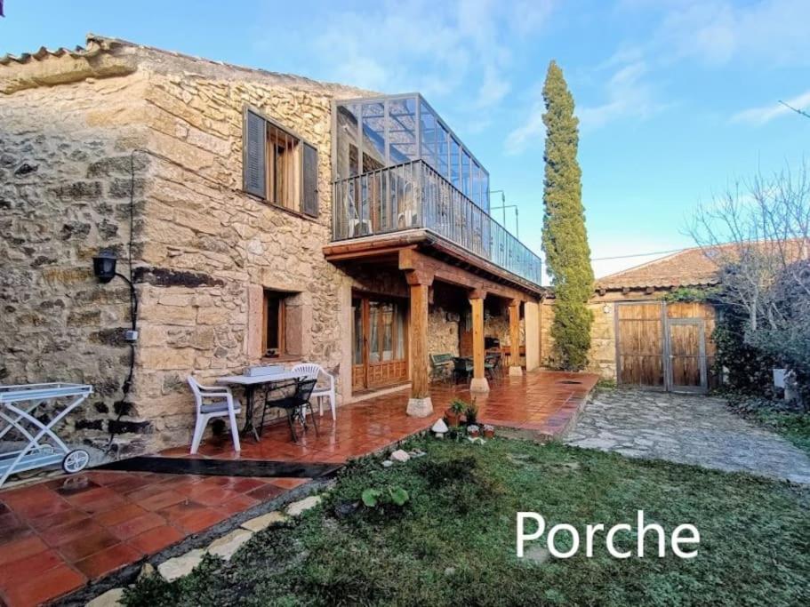 a stone house with a balcony and a patio at Casa Florentino Casa centenaria in Torre Val de San Pedro