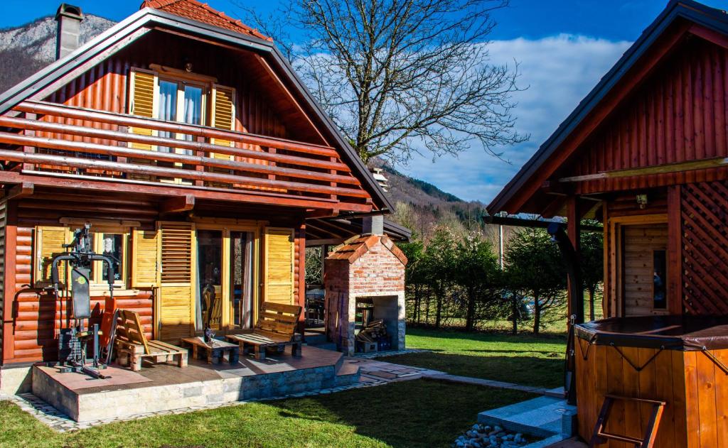 ein Blockhaus mit einer Veranda und einem Hof in der Unterkunft Petit chalet Belosevic in Kuželj