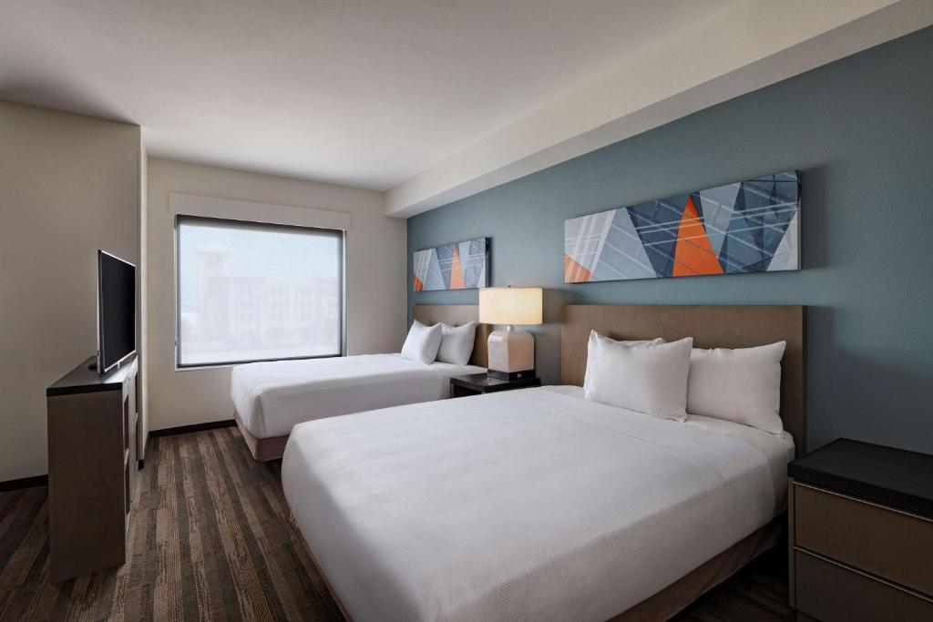 um quarto de hotel com duas camas e uma televisão em Hyatt House Carlsbad em Carlsbad