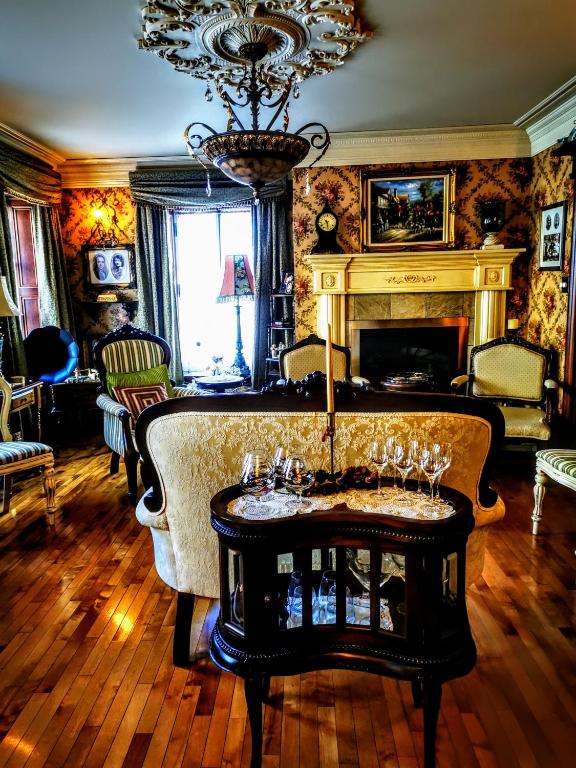a living room with a fireplace and a table with wine glasses at Auberge J.A Moisan in Quebec City