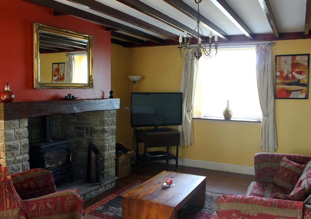 a living room with a fireplace and a television at Hidden gem apartment in sleepy Durham village. in Cornsay