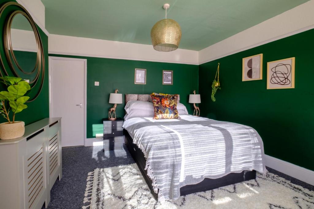 Dormitorio verde con cama y espejo en Convenient Step-Free Access Apartment with 6 Parking Spaces, Just 2 Minutes from Town, en Ryde