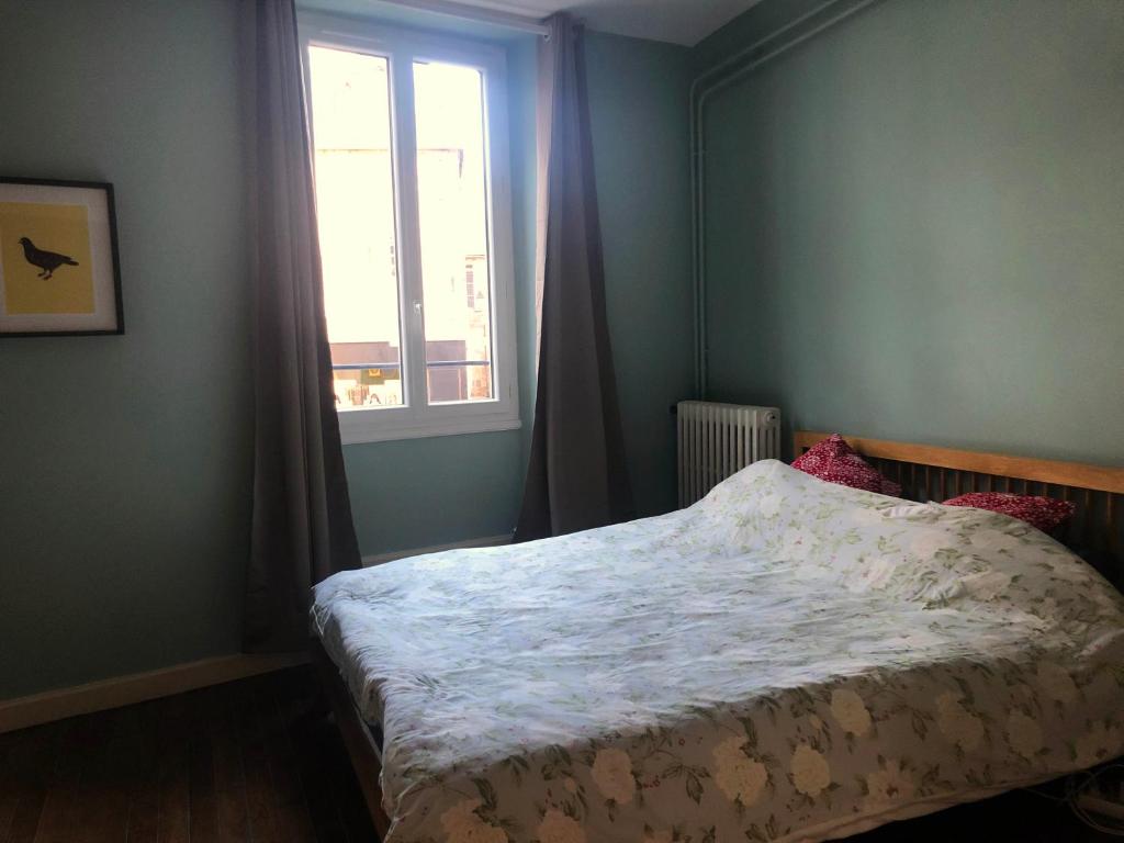 een slaapkamer met een bed en een raam bij Charming one bedroom apartment in Brive center in Brive-la-Gaillarde