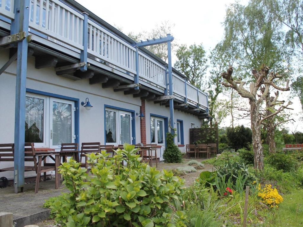 ein Haus mit einer Terrasse, einem Tisch und Bänken in der Unterkunft Mod Apartment in Rerik Germany with Terrace in Rerik