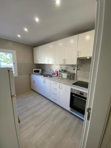 a kitchen with white cabinets and a stove top oven at Monte Gordo apartment in Monte Gordo