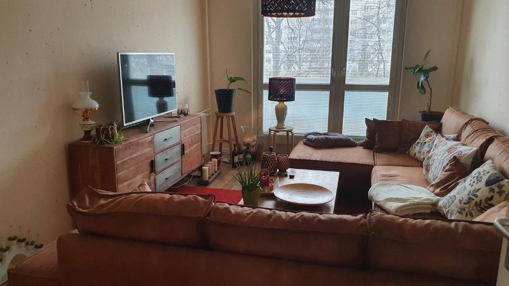 ein Wohnzimmer mit einem Sofa und einem TV in der Unterkunft Berlin mednow 1 in Berlin