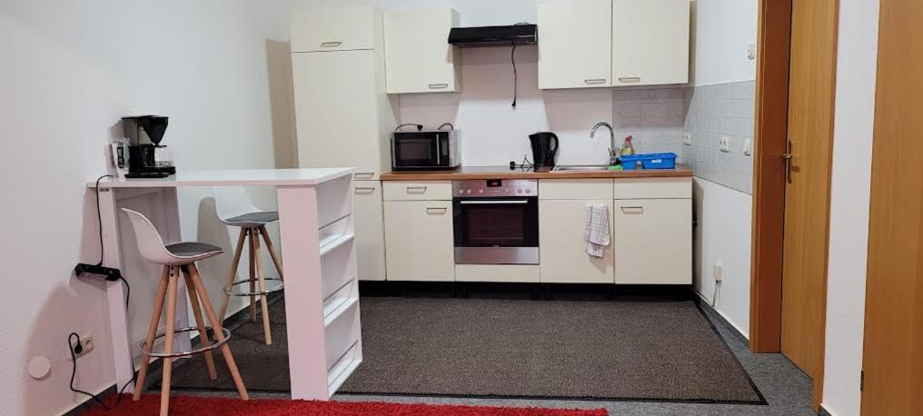 cocina con armarios blancos y encimera blanca en Gästewohnung Kristall 3, en Salzwedel