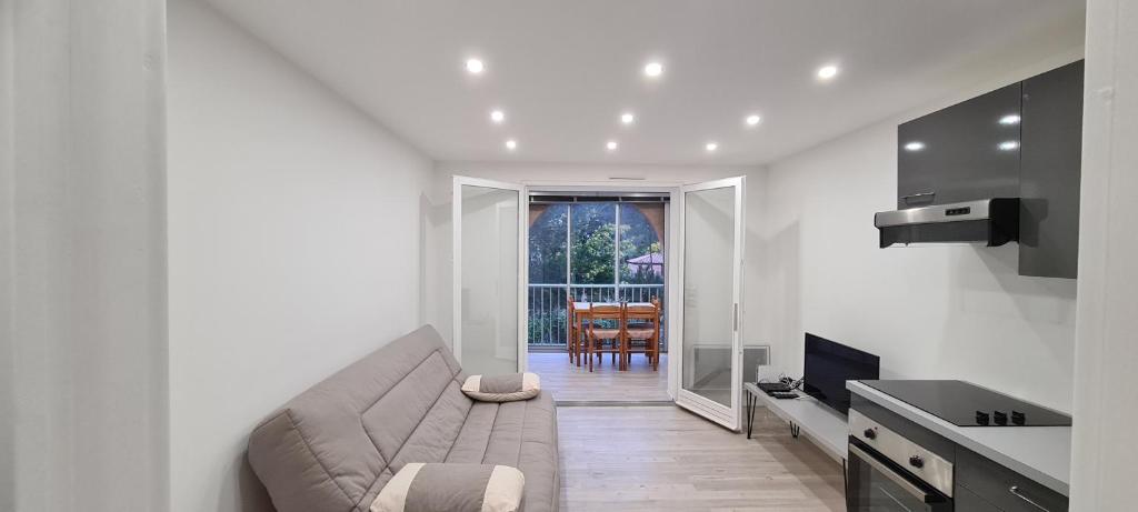 un salon avec un canapé et une cuisine dans l'établissement le calypso, à Saint-Aygulf