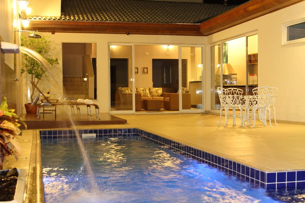- une piscine avec une fontaine dans une maison dans l'établissement Hotel Água Viva - Cachoeira Paulista - SP - Próximo a Canção Nova, à Cachoeira Paulista