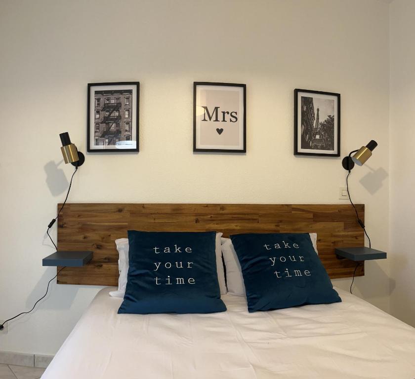 a bedroom with a bed with two blue pillows at le Rialto **** : cozy T2 avec parking / v-rent in Annecy