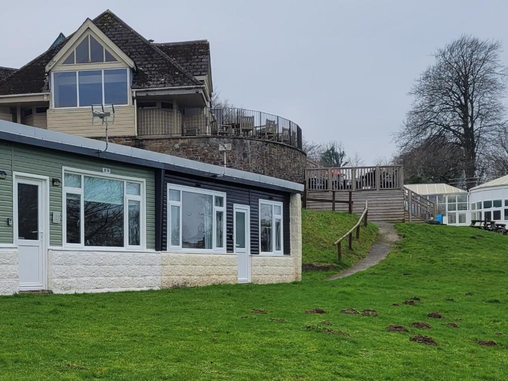 a house on a hill with a grass yard at 26 sea valley, Bideford Bay Holiday Park in Bucks Mills