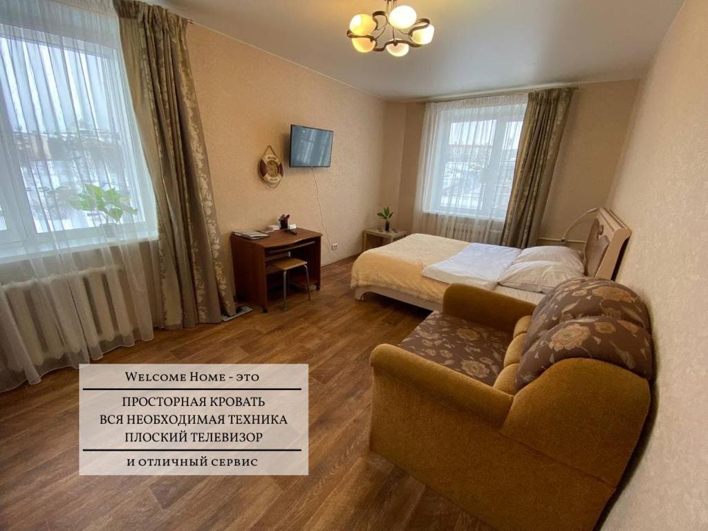 ペトロパブロフスク・カムチャツキーにあるWELCOME HOME Aparts & Tours 21 Бесконтактное заселениеのベッドルーム1室(ベッド1台、椅子、サイン付)
