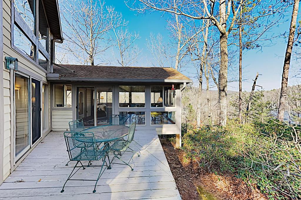 une terrasse couverte d'une maison avec une table et des chaises dans l'établissement Narnia on Earth, à Lake Lure