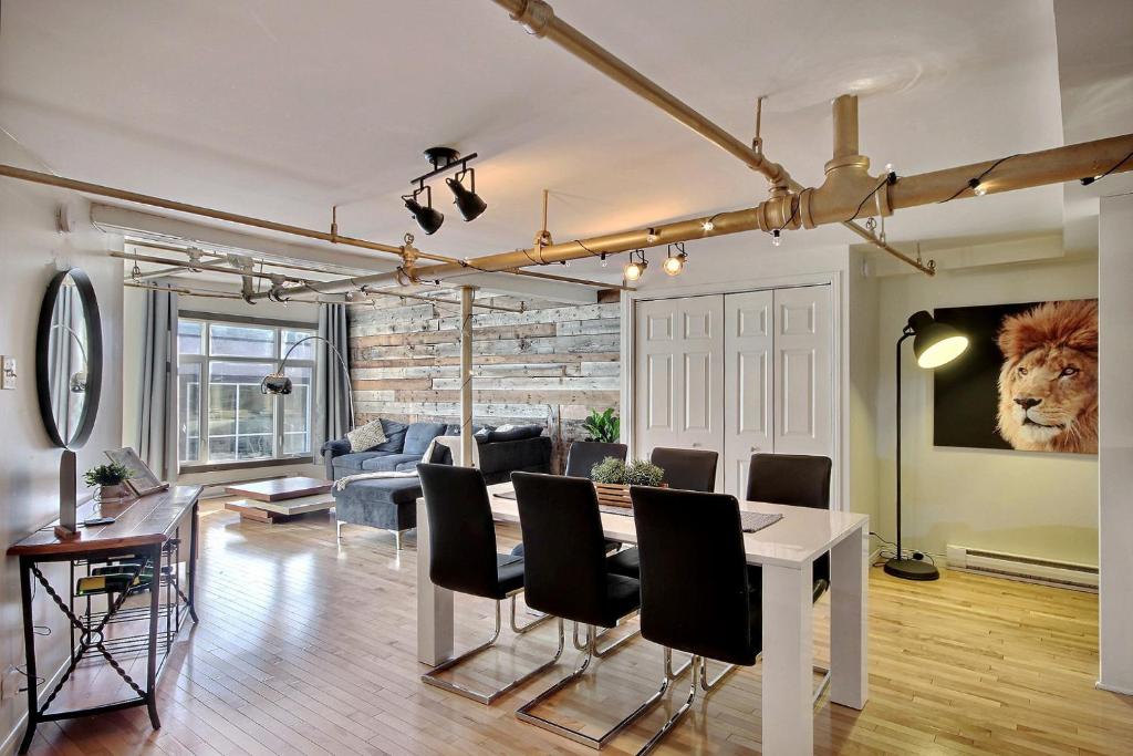 魁北克市的住宿－Lion's Den // Spacious 1500 sqft (2 WC) - Downtown，用餐室以及带桌椅的起居室。