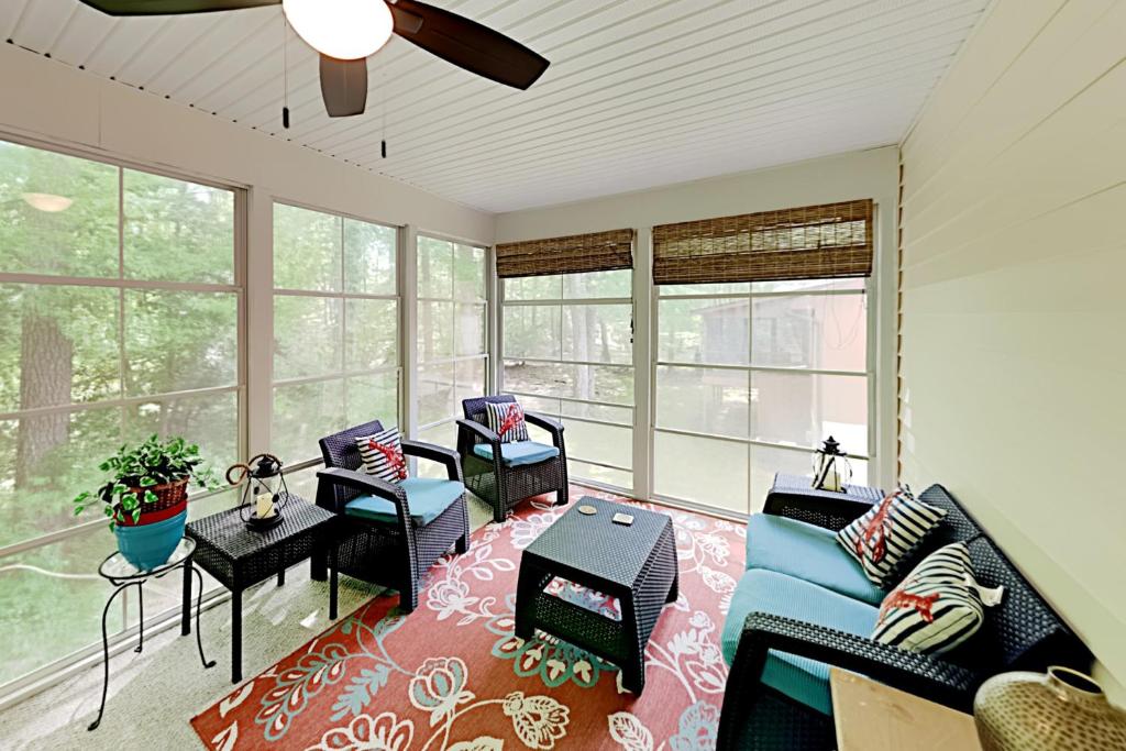 ein Wohnzimmer mit Sofa, Stühlen und Fenstern in der Unterkunft Coral Shells in Ocean Pines