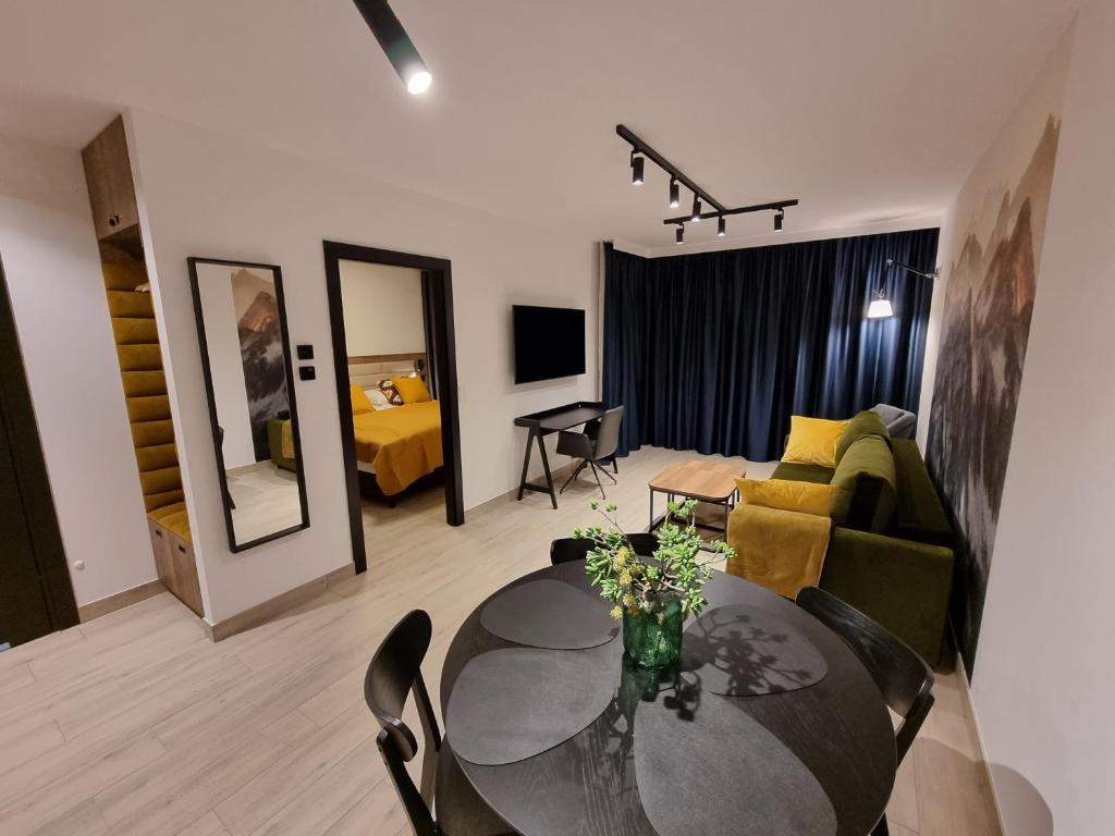 een woonkamer met een tafel en een bank bij Apartament Hala Kamienicka in Bielsko-Biala