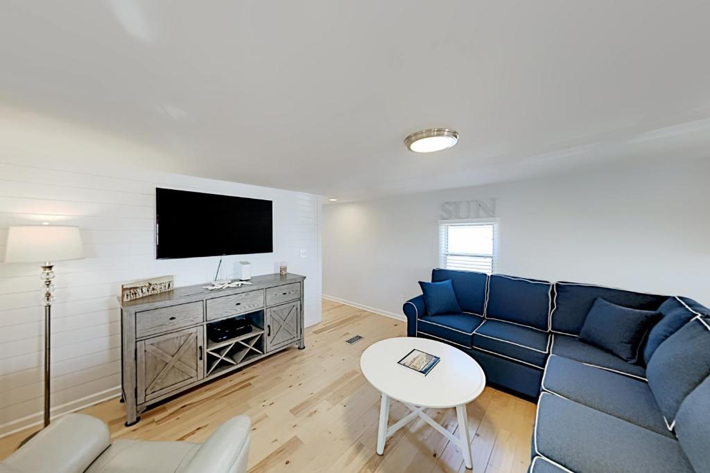 a living room with a blue couch and a tv at Sandyhill Sun in Ocean City