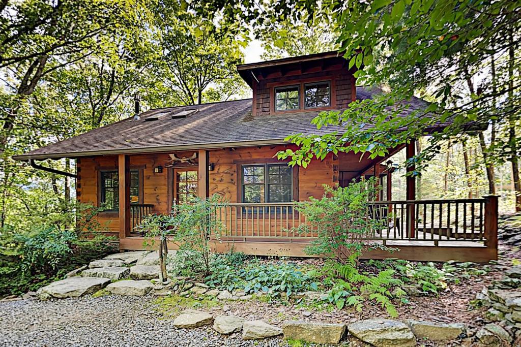 a log cabin in the woods with a porch at Elkhorn Cabin in Asheville