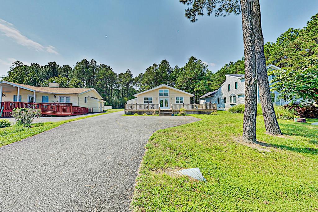 una calle con casas, un árbol y una entrada en Salty Sea Life, en Ocean Pines