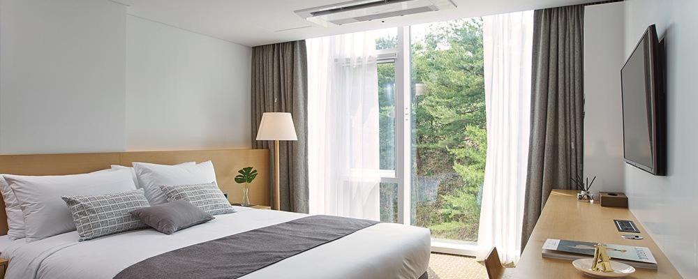 Postel nebo postele na pokoji v ubytování Naksan Beach Hotel