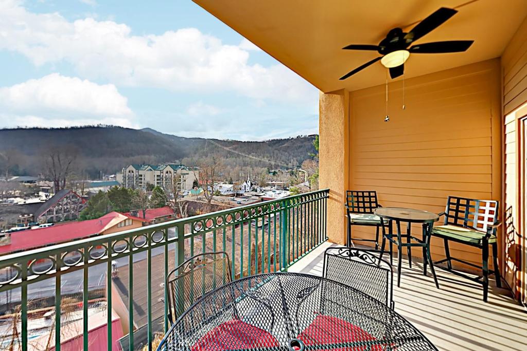 a balcony with a table and chairs and a ceiling fan at Summit Manor Condos Unit B3062 in Gatlinburg