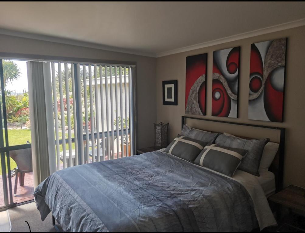 a bedroom with a bed with paintings on the wall at Sunrise suite in Collingwood