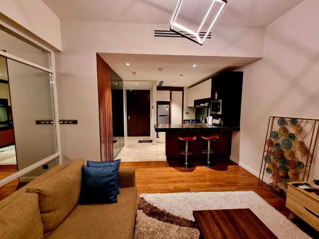Anggun Luxury Suite في كوالالمبور: غرفة معيشة مع أريكة وطاولة