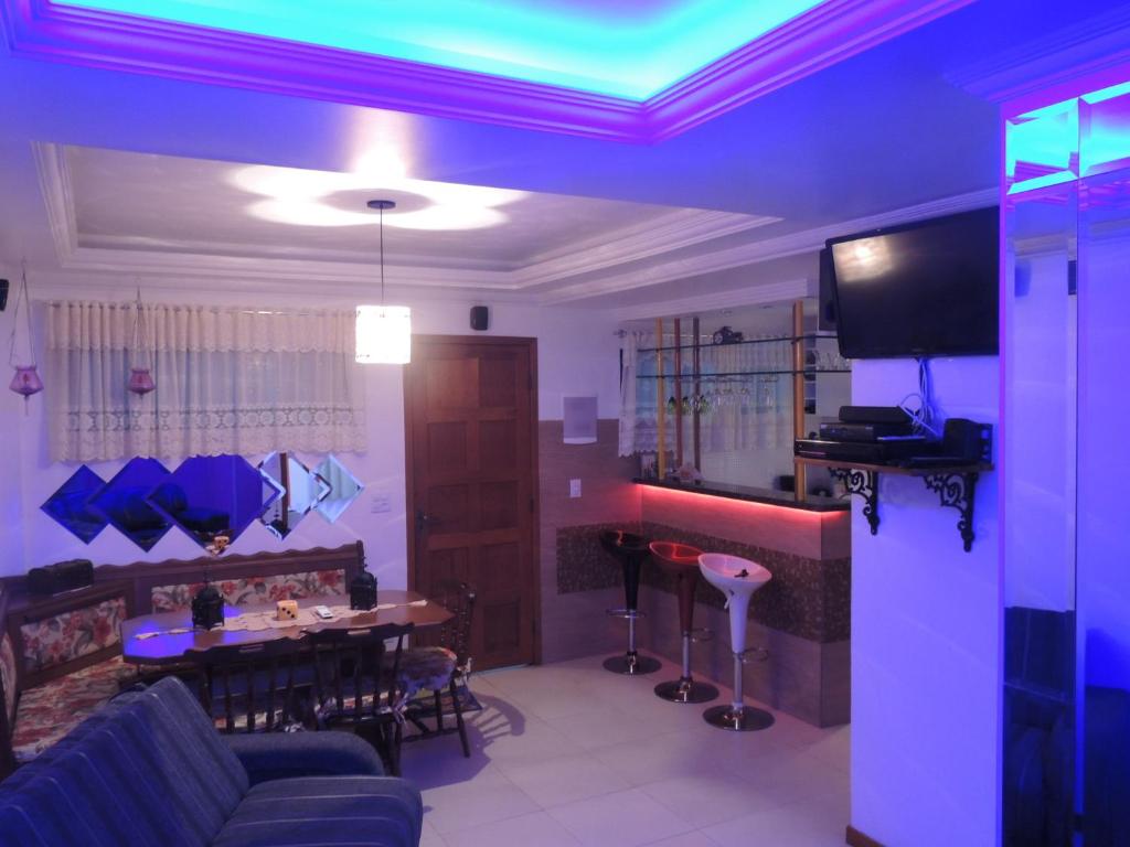 a living room with a couch and a table with a bar at Apartamento Villa da Praia Residence in Arraial do Cabo