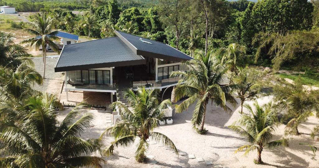 einem Luftblick auf ein Haus am Strand mit Palmen in der Unterkunft Eagle Bay Retreat Borneo Beach Villas Beach Front in Kumbatang