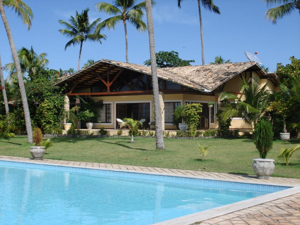 une maison avec une piscine en face d'un complexe dans l'établissement Holiday Villa Praia da Pipa-5 Suites,Areá Gourmet by PipaCharme, à Pipa