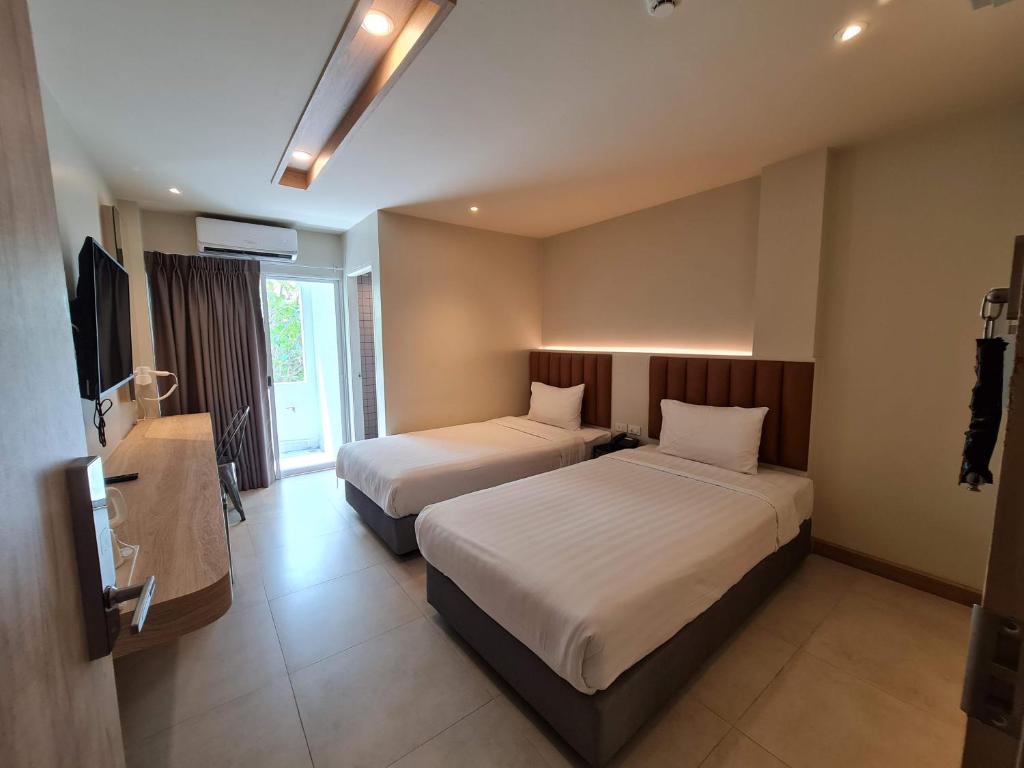 Habitación de hotel con 2 camas y TV en The Phoenix Hotel Bangkok - Suvarnabhumi Airport, en Lat Krabang