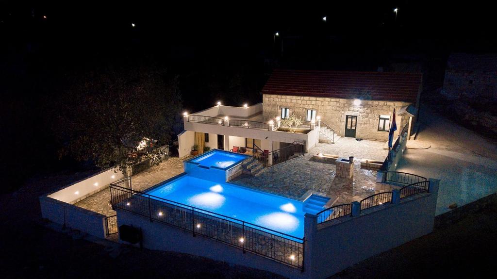 - une vue aérienne sur une maison avec une piscine la nuit dans l'établissement Villa Stipe - with pool, à Vodenjak