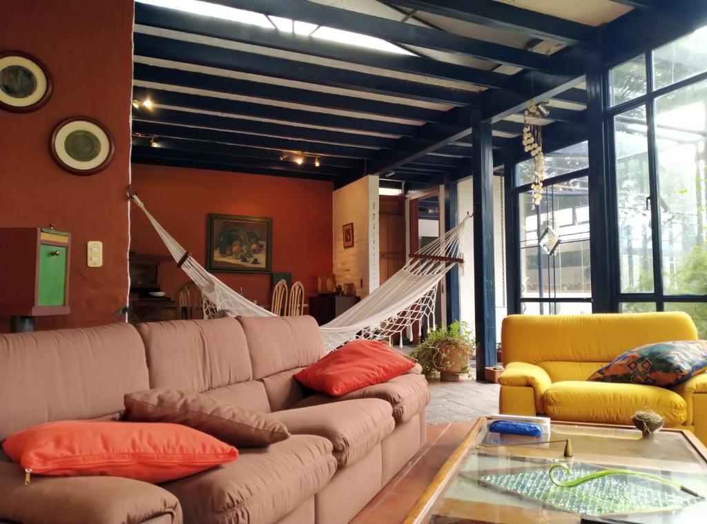 a living room with a couch and a glass table at Casa del Aguacate Cumbaya - Tumbaco in Cumbayá