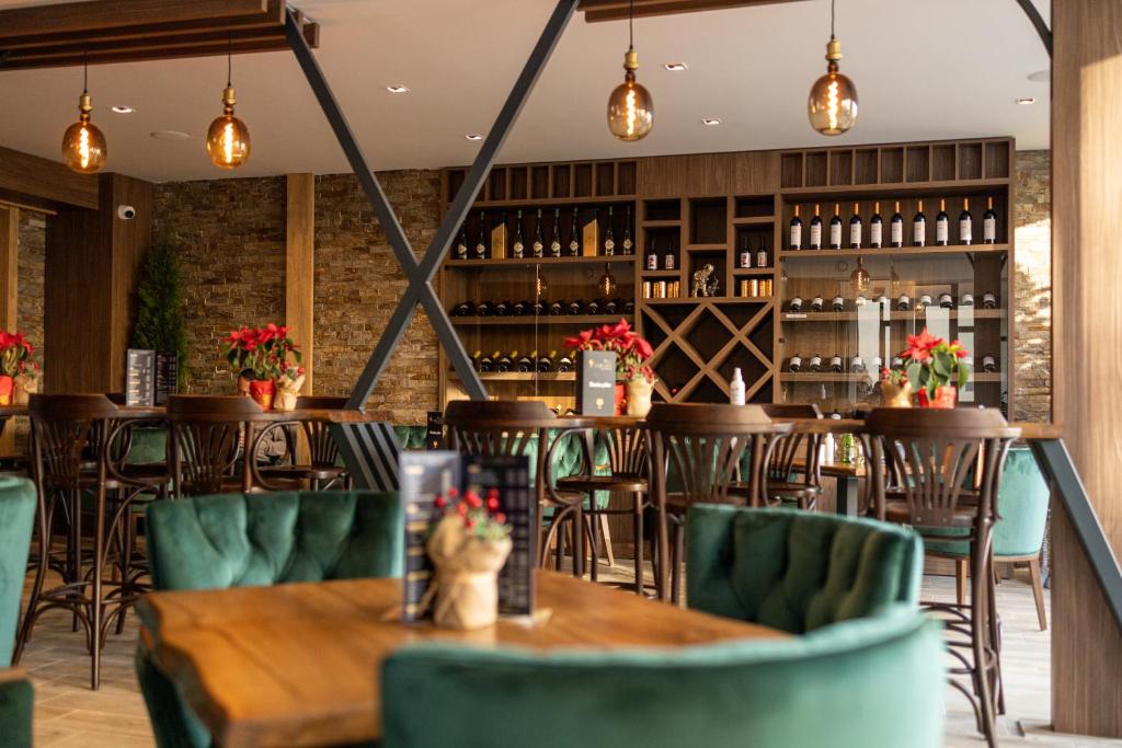 um restaurante com mesas de madeira e cadeiras verdes em All Seasons Residence em Zlatibor