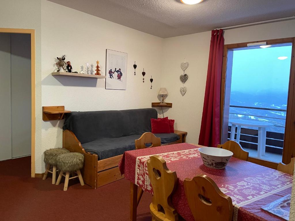 una sala de estar con un sofá y una mesa en Le Corbier résidence Les Pistes, en Le Corbier