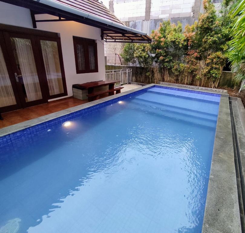 a large blue swimming pool in a backyard at Villa Dago Syariah, Familiy Only, View Indah ke Bukit Dago in Bandung