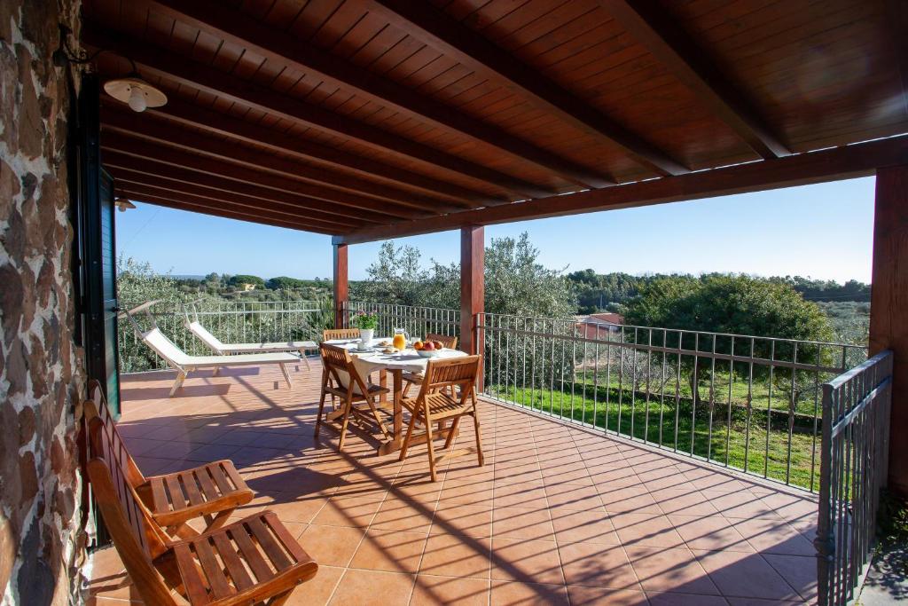 a patio with a table and chairs on a deck at Casa Osala in Orosei