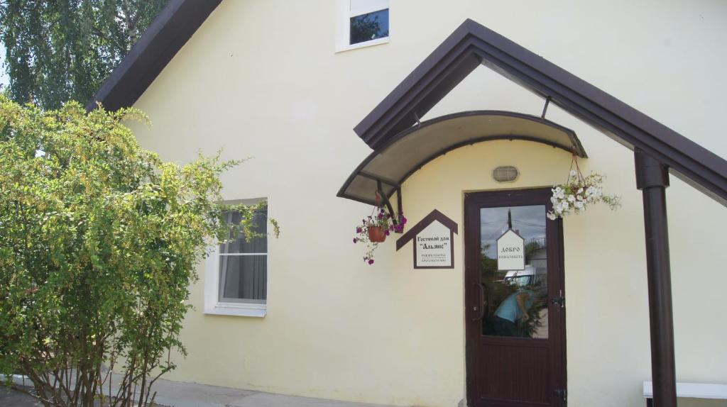 a white house with a brown door and a window at Гостевой дом Альянс in Velikiy Novgorod