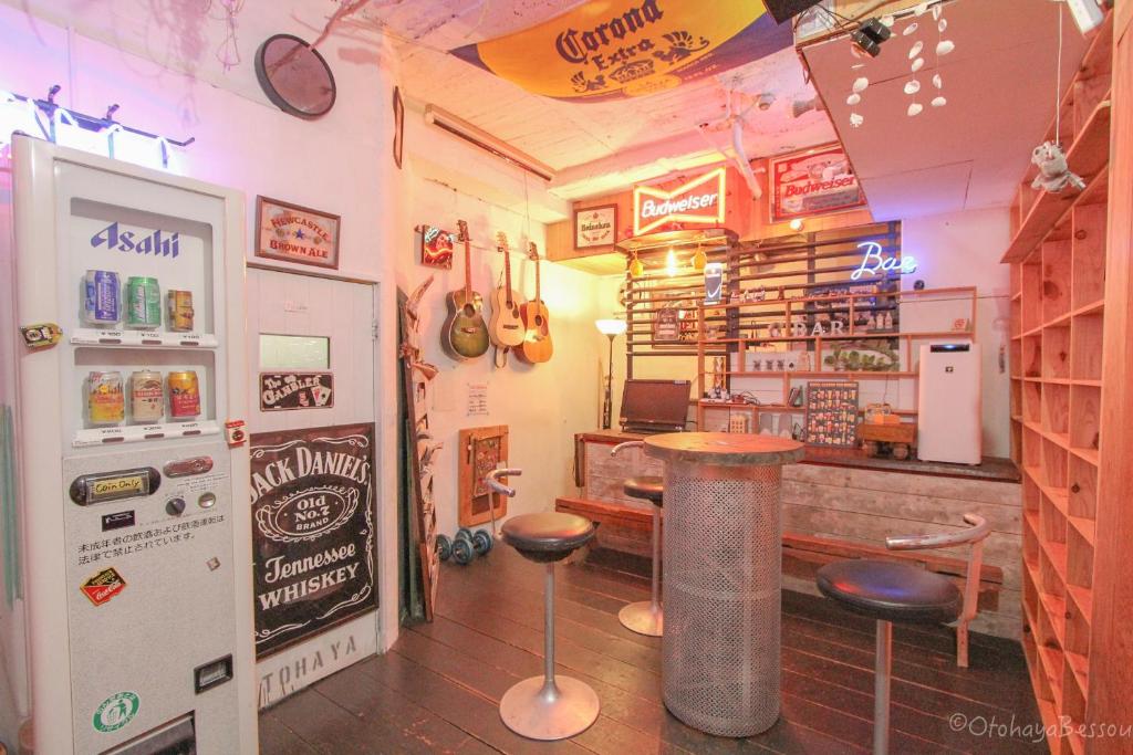 a restaurant with a bar with a table and stools at Otohaya Guesthouse in Nagoya