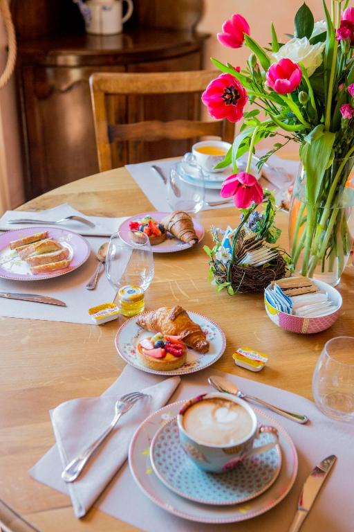 stół z talerzami jedzenia i wazonem kwiatów w obiekcie Leonardo Resort w mieście Imperia
