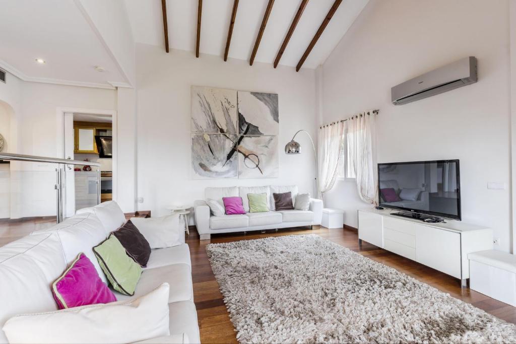 a living room with white furniture and a flat screen tv at Los Naranjos 7 in Atamaría