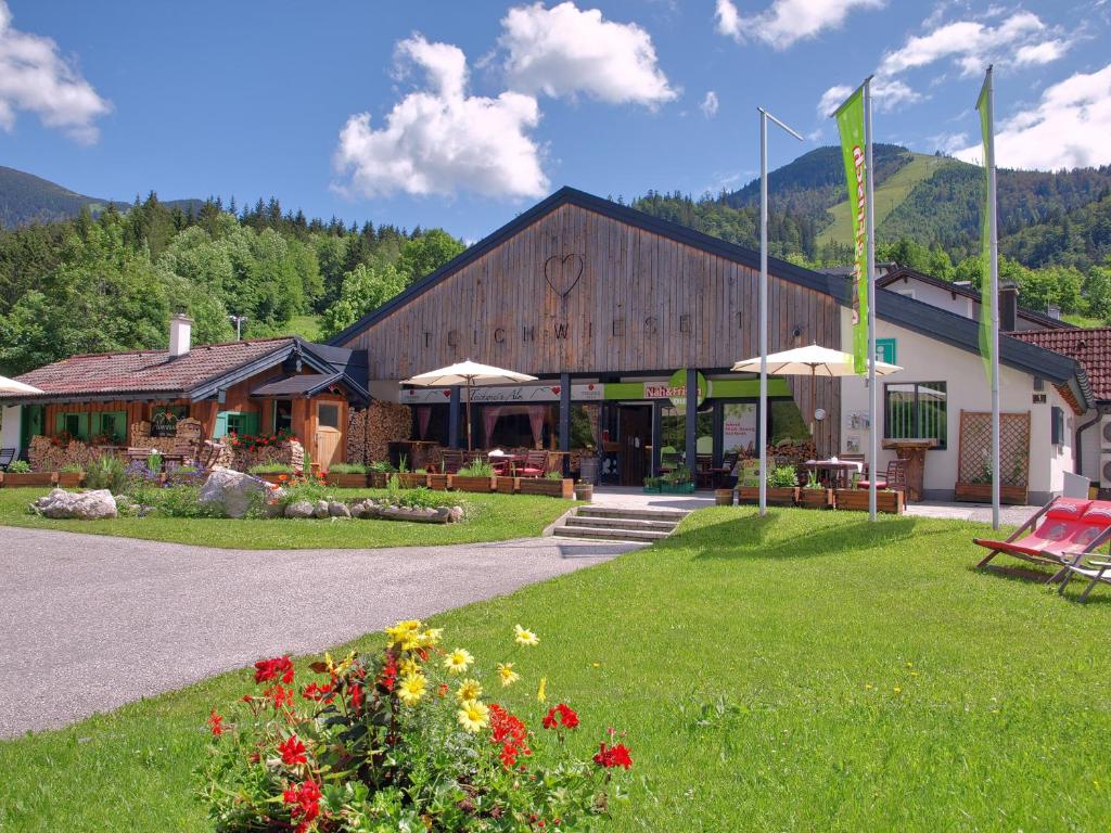 ein Gebäude mit einer Flagge und Blumen davor in der Unterkunft Teichwies'n Alm in Lackenhof