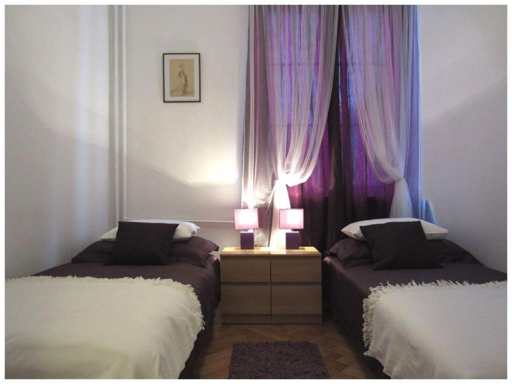 a bedroom with two beds and purple curtains at Unique Warsaw Center Apartment in Warsaw