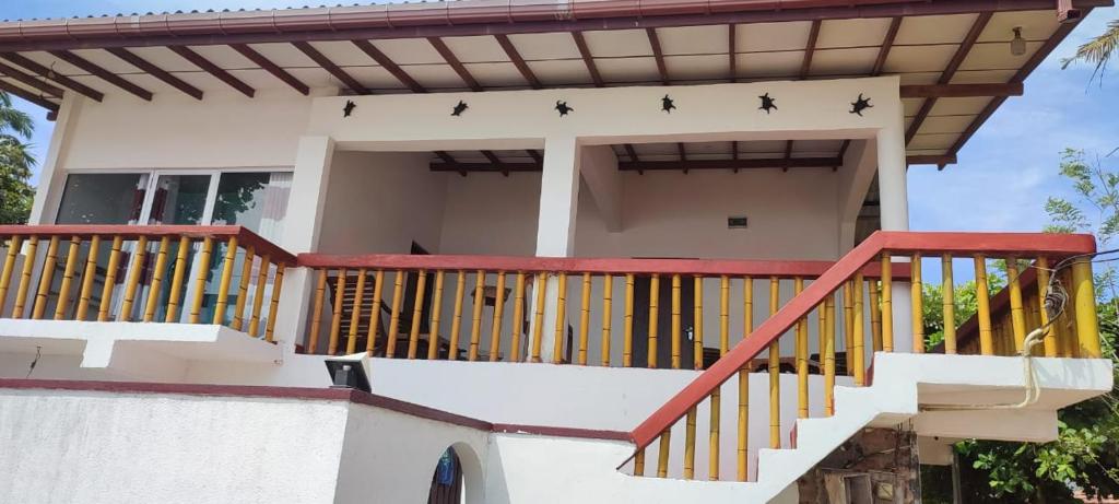 a house with a balcony with four stars on it at Kiralawella Beach Inn in Matara