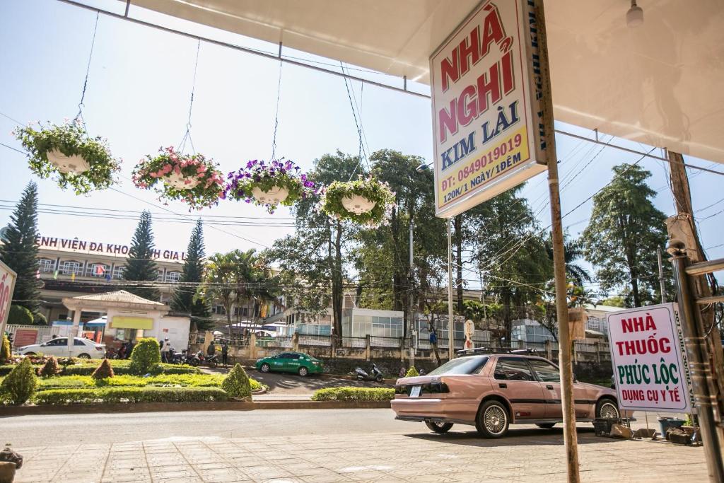 un negozio con un'auto parcheggiata in un parcheggio di Nhà Nghỉ Kim Lài - Đối diện bệnh viện tỉnh Gia Lai -132 Tôn Thất Tùng a Pleiku