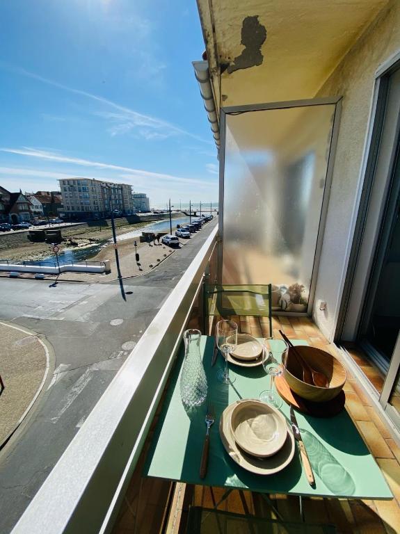 une table sur un balcon avec vue sur la plage dans l'établissement Vue mer et Garage privé, studio balcon plein Sud, à Wimereux