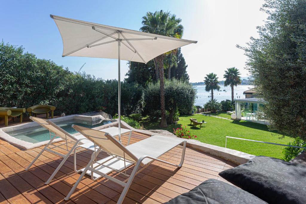 a patio with two chairs and an umbrella at Calapetra Resort in Fontane Bianche