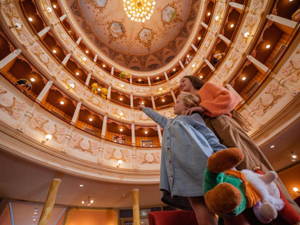 een vrouw die een kind op een plafond vasthoudt bij Plopsa Hotel in De Panne