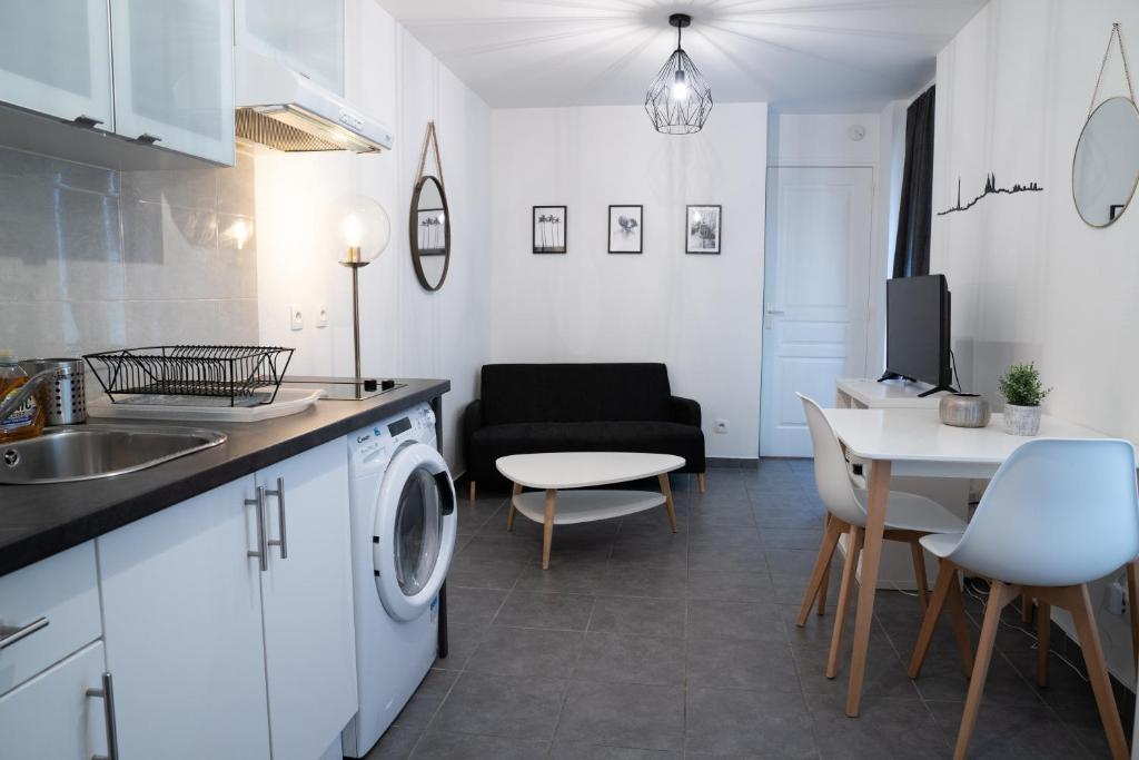 a kitchen and living room with a washing machine and a table at Apart By Jo in Saint-Germain-en-Laye